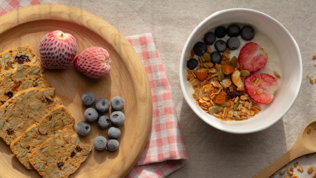 red raspberry and blueberry on white ceramic bowl