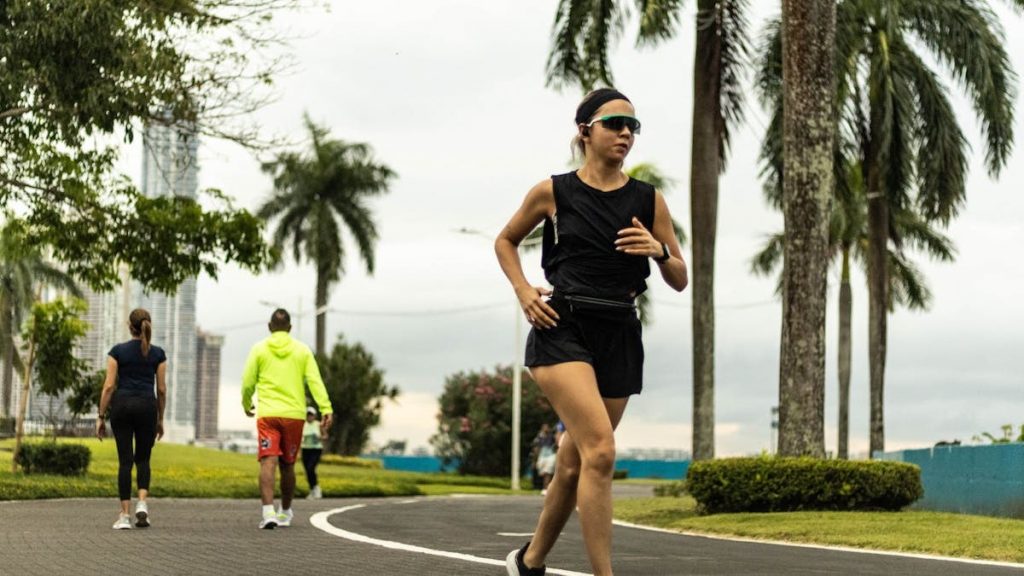 Woman jogging in a tropical park in Panama City on an overcast day.